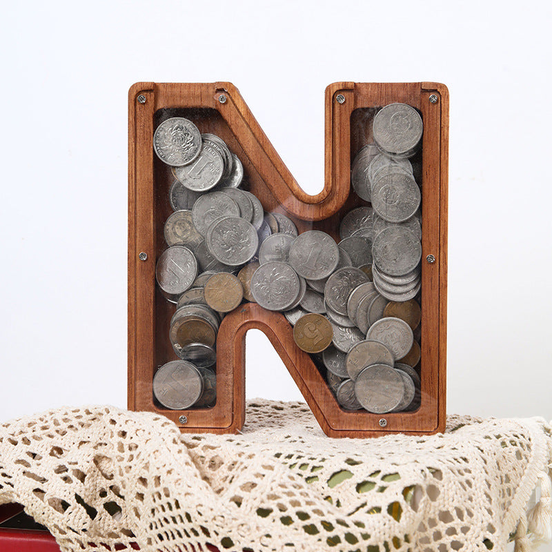 Custom wooden letter N piggy bank filled with coins, ideal for teaching kids about saving money.