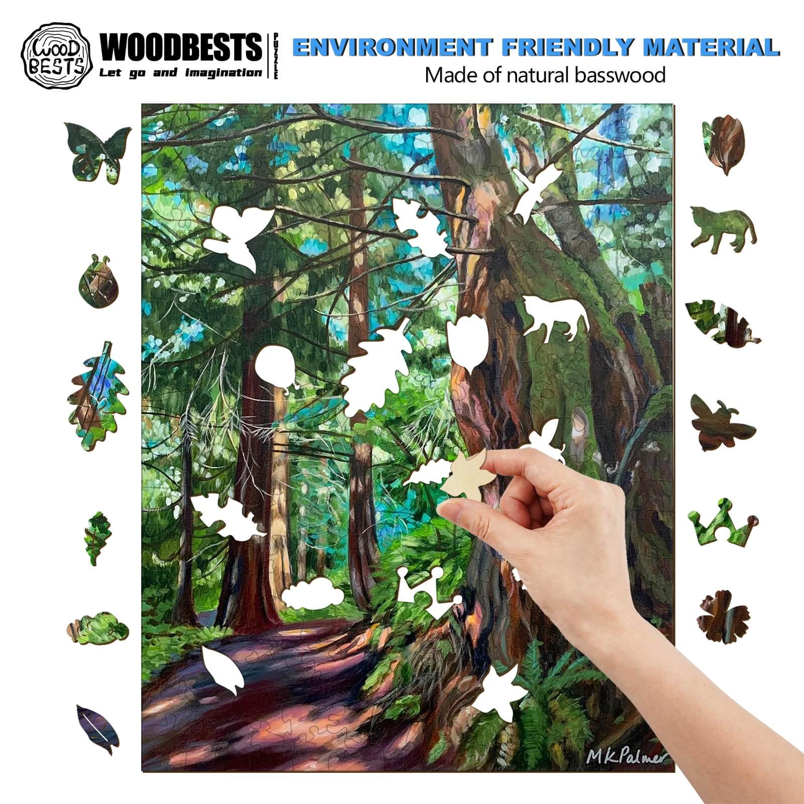 Hand placing natural basswood cutouts on a vibrant forest painting by Marianne K Palmer, showcasing artistic creativity.