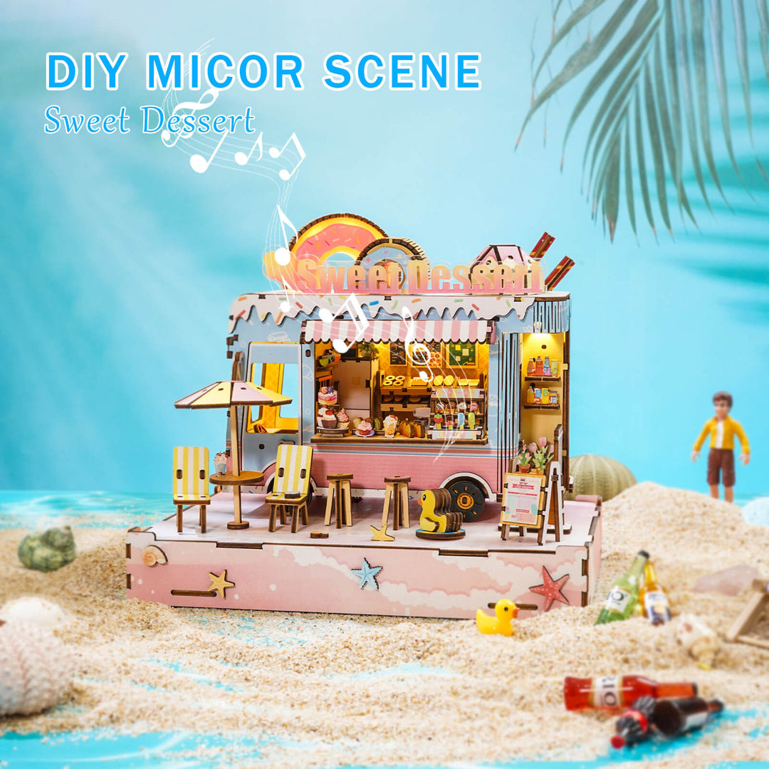 Colorful DIY miniature dessert cart scene with detailed wooden design on sandy beach.