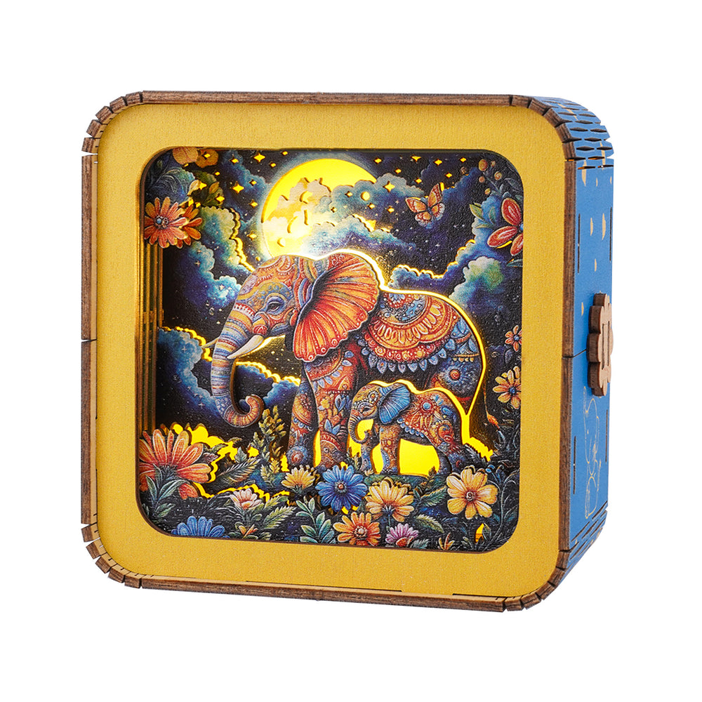 Colorful 3D wooden puzzle night light featuring an intricate elephant design under the moon and flowers.