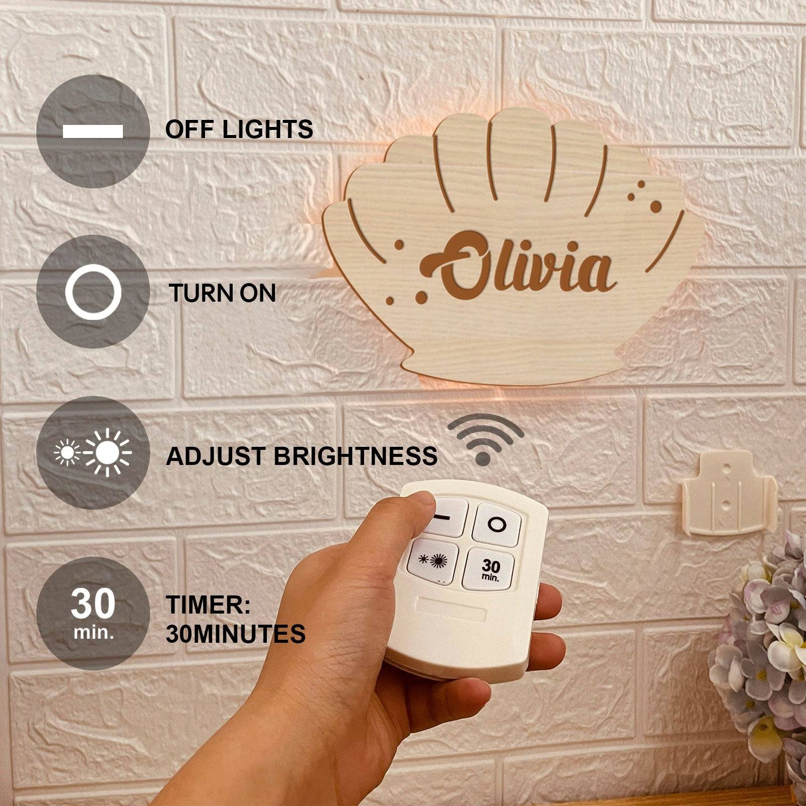 Personalized wooden marine-themed wall light with remote control for adjusting brightness in a child's bedroom.