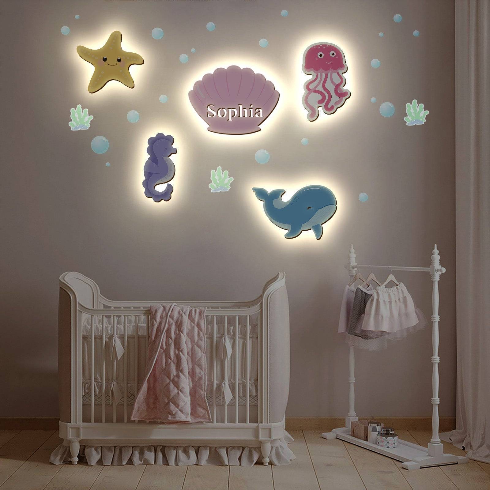 Marine-themed wooden wall light set for baby's room, featuring a starfish, jellyfish, shell, seahorse, and whale.