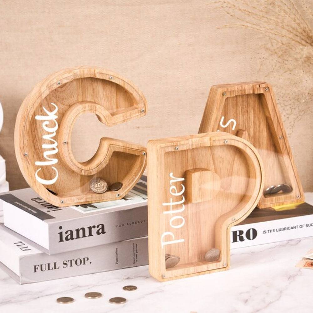 Personalized wooden letter piggy bank in the shape of G and A, designed for children to save money.